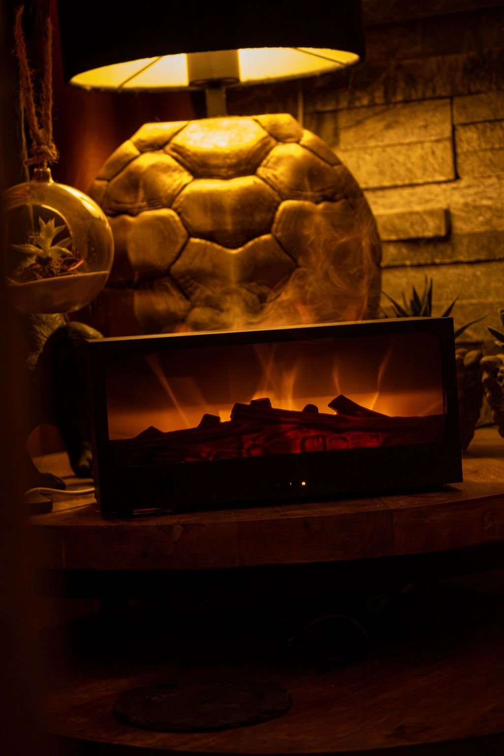 De zwarte Solafera Haard aan op een ronde bijzettafel, onder een schemerlamp