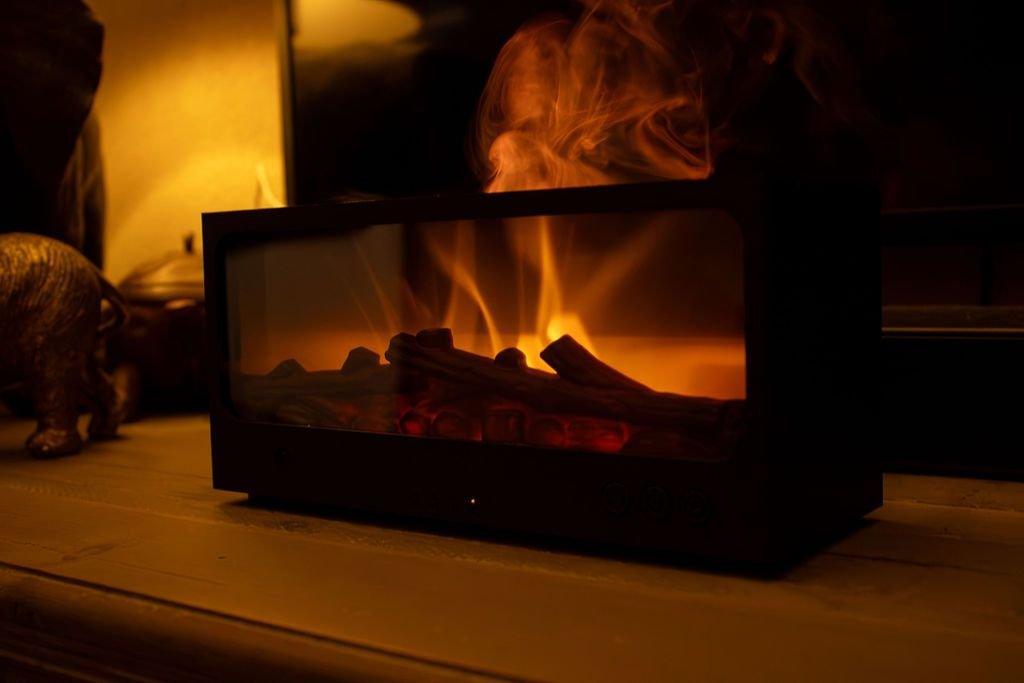 De zwarte Solafera Haard aan op een houten kast, met een schemerlamp erachter